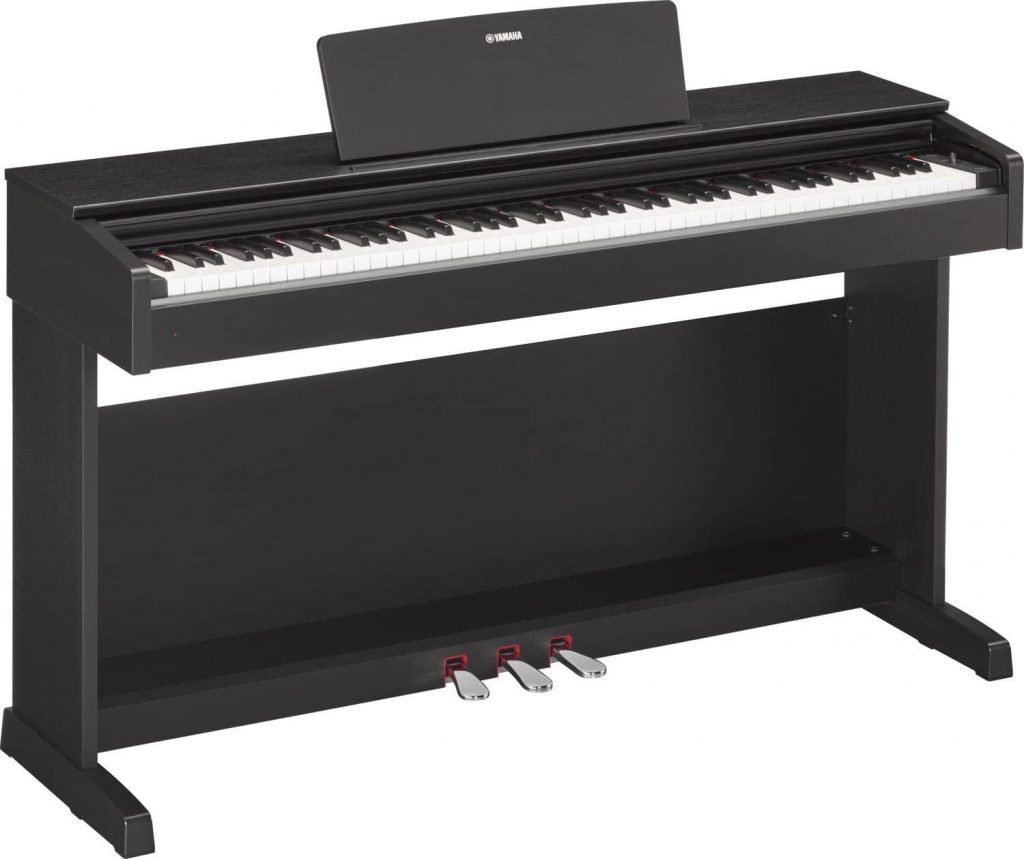 Un piano droit numérique non portable avec les trois pédales d'un piano à queue acoustique